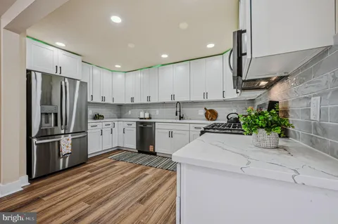 a kitchen with a sink stainless steel appliances and white cabinets