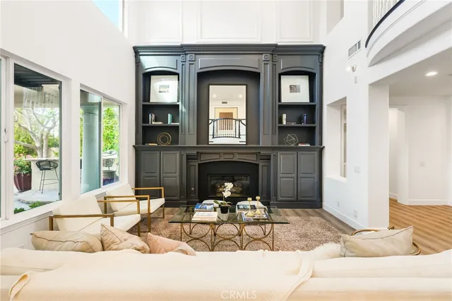 a living room with furniture a fireplace and a large mirror