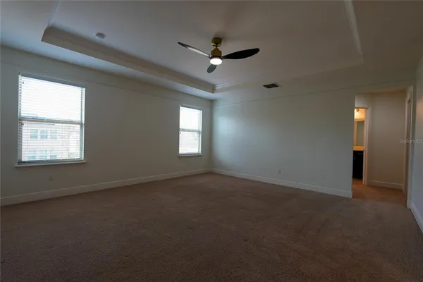 an empty room with a window and a ceiling fan
