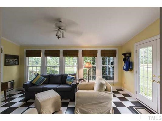9123 South Lowell Road Bahama, NC 27503 - Photo 11 of 25 A bright, fun room located off of the kitchen has a pet access door from the front porch and also has a door that opens to the adjacent concrete patio for convenient outdoor grilling. Sunroom