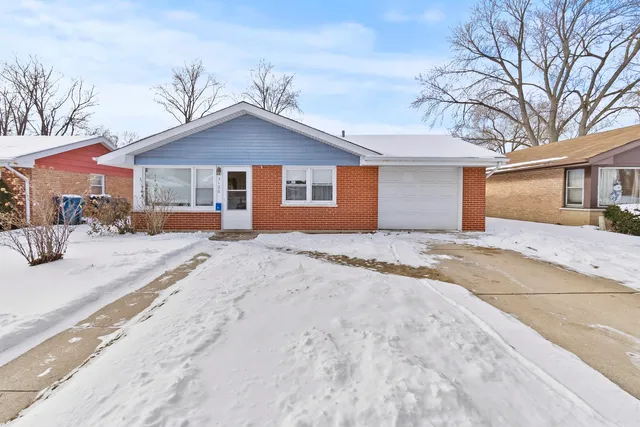 a view of a house with a yard covered in snow