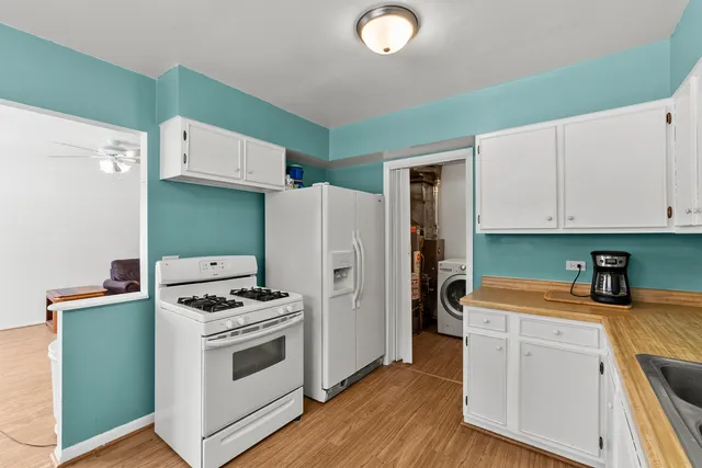 a kitchen with white cabinets and white appliances