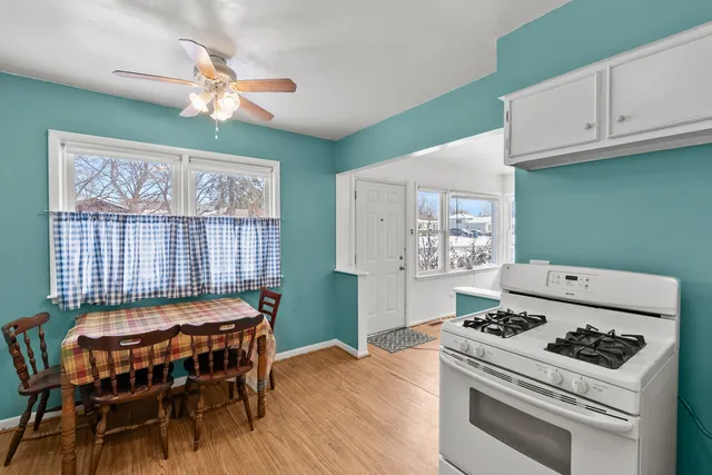 a kitchen with a stove a refrigerator and a dining table