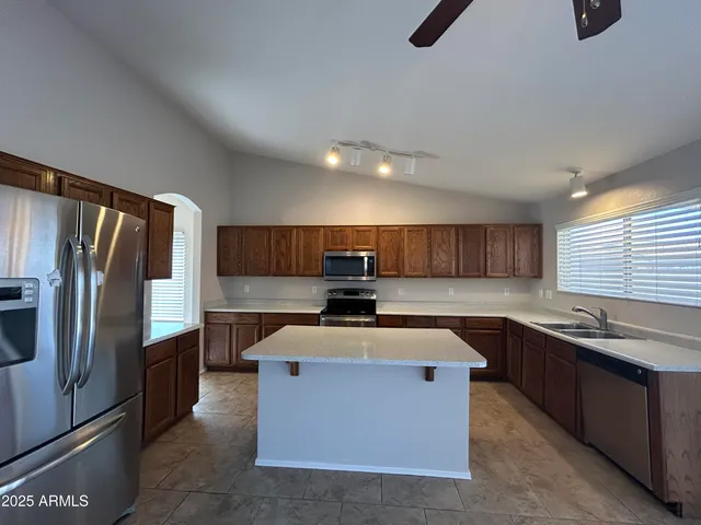 a kitchen with stainless steel appliances granite countertop a sink stove and refrigerator