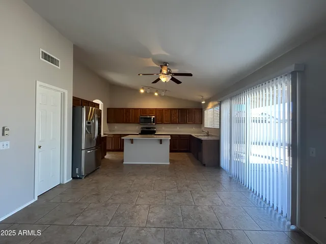 a view of a kitchen with a sink stainless steel appliances cabinets and a large window