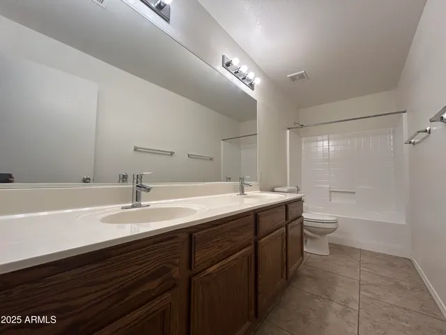a bathroom with a granite countertop sink a toilet and a bathtub