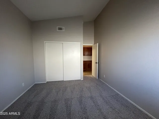 a view of an empty room with closet and wooden floor