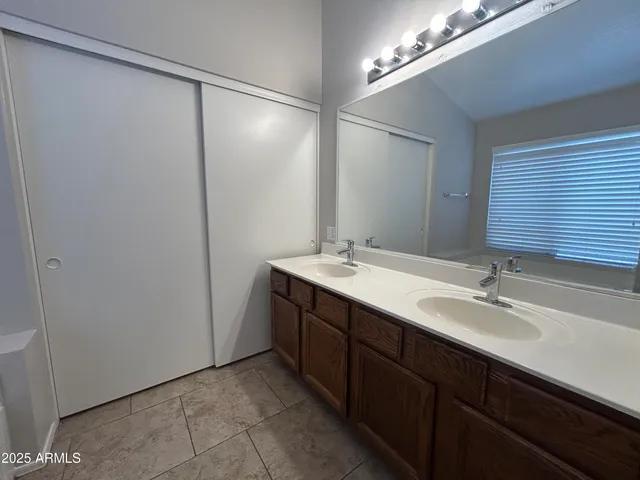 a bathroom with a double vanity sink and a mirror