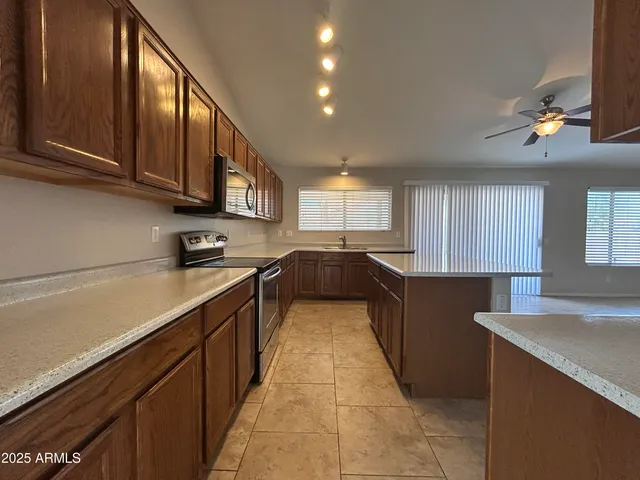 a kitchen with stainless steel appliances granite countertop a sink a stove counter space and cabinets
