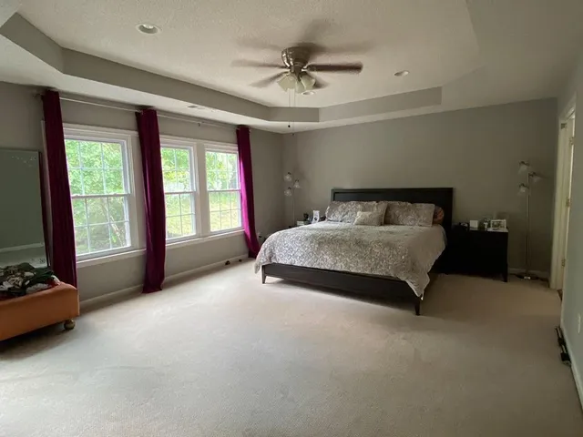 a spacious bedroom with a bed and a ceiling fan