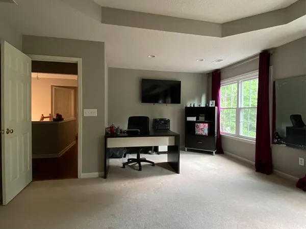 a workspace with a large window and a livingroom