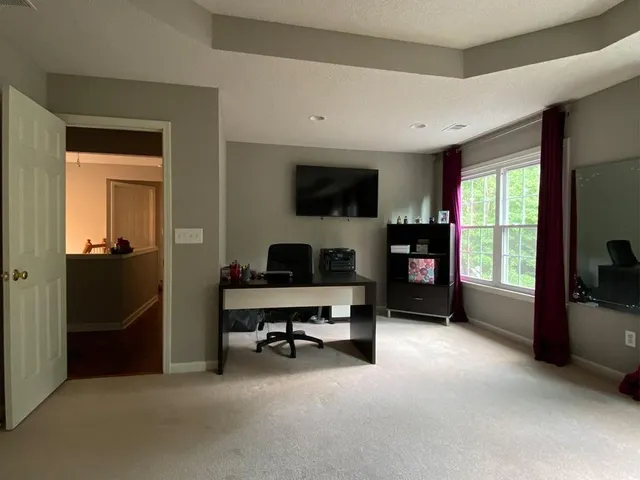 a workspace with a large window and a livingroom