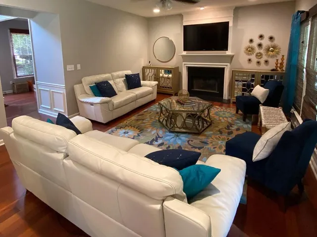 a living room with furniture a fireplace and a flat screen tv