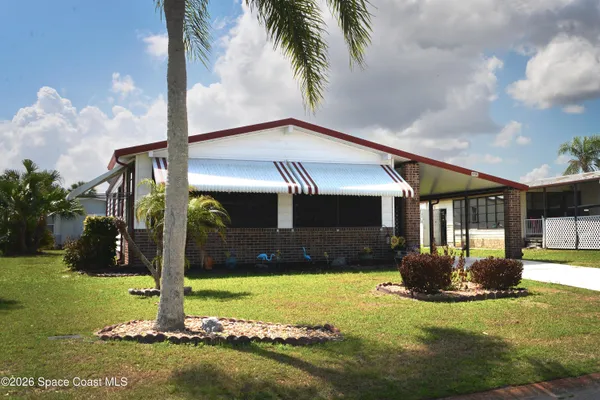 a view of a livingroom with a chandelier fan and windows