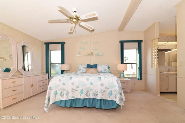 a bedroom with a large bed and a chandelier