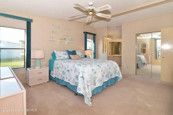 a bedroom with a large bed and a chandelier
