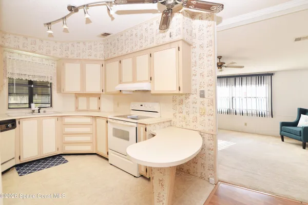 a dining room with furniture a chandelier and wooden floor