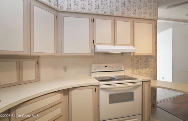 a white kitchen with stainless steel appliances white cabinets and a refrigerator