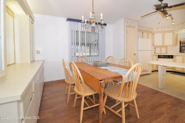 a dining room with furniture a chandelier and wooden floor