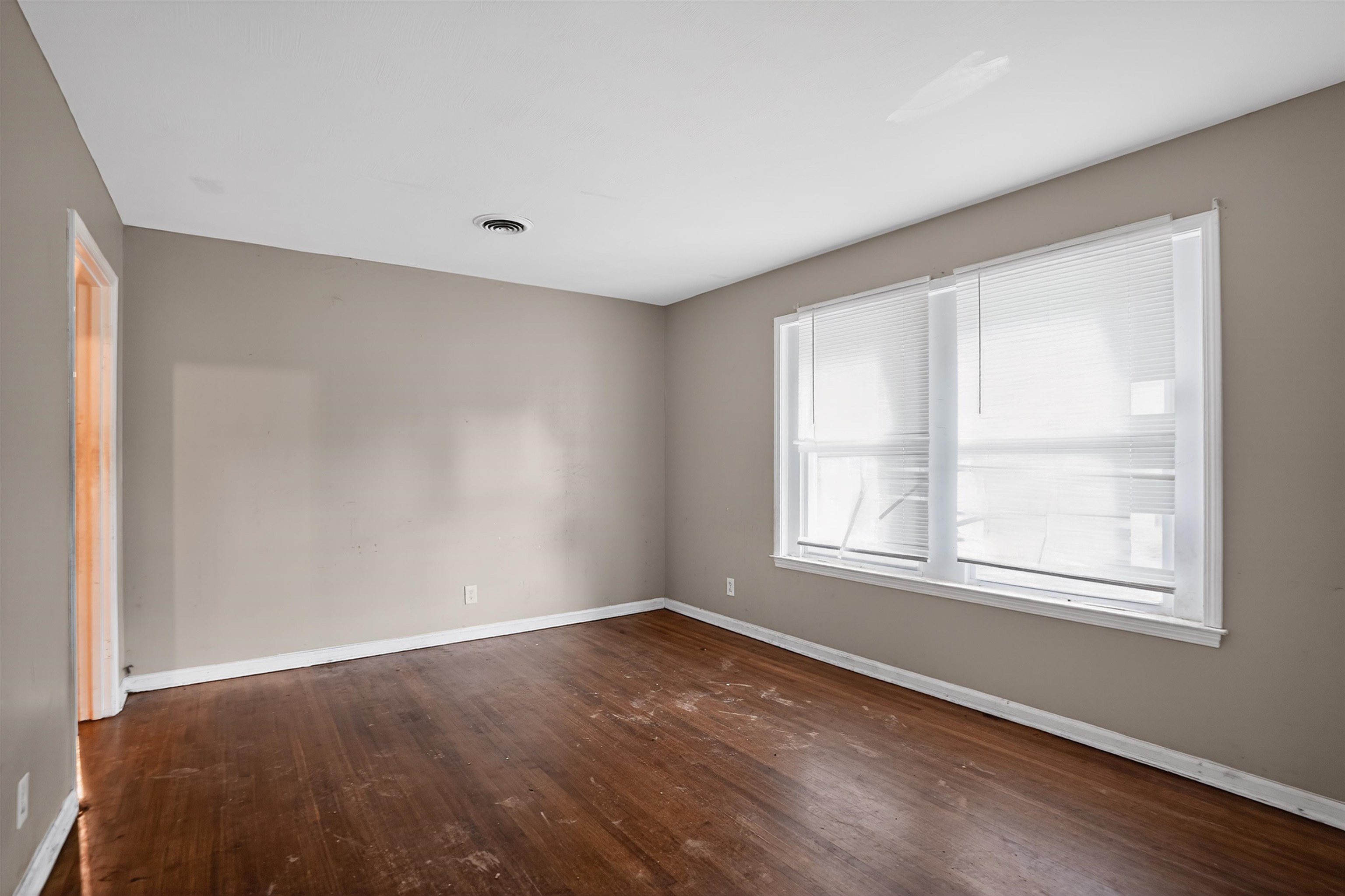 1890 Pennel Road Memphis, TN 38116 - Photo 7 of 25 Spacious room featuring wood-finish flooring, neutral-toned walls, and a large multi-pane window with white blinds