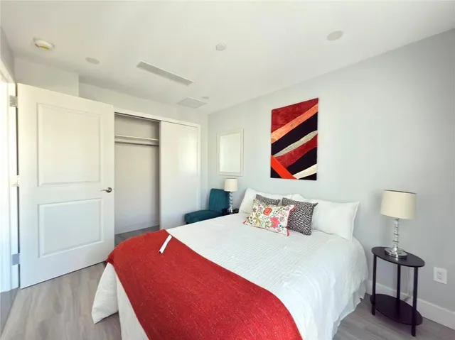 a bedroom with a bed and a painting on the wall