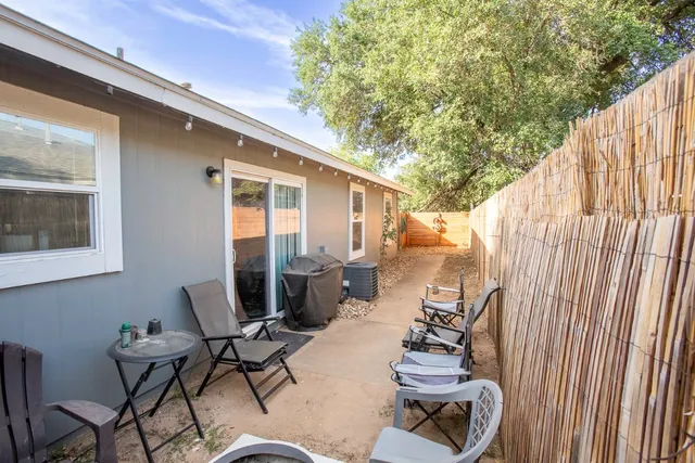 a view of a patio with table and chairs with wooden fence and plants