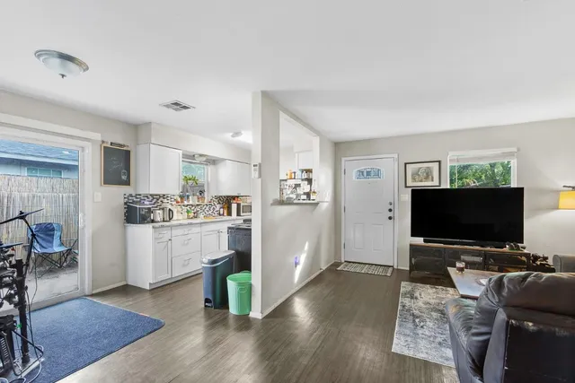 a kitchen with cabinets and wooden floor