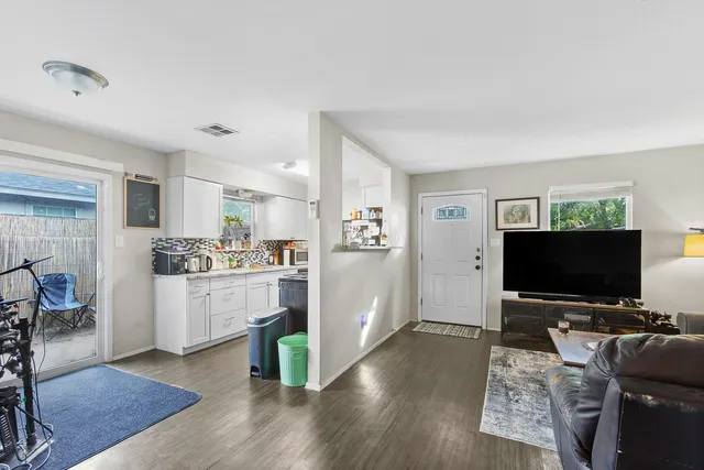 a kitchen with cabinets and wooden floor