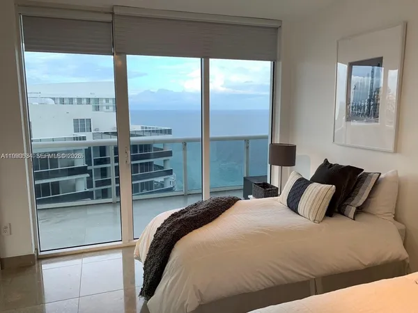 a bedroom with a large bed and a large window