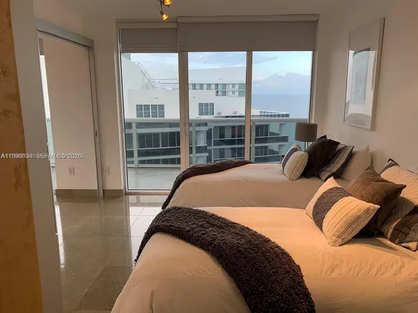 a bedroom with a bed and glass walk in closet