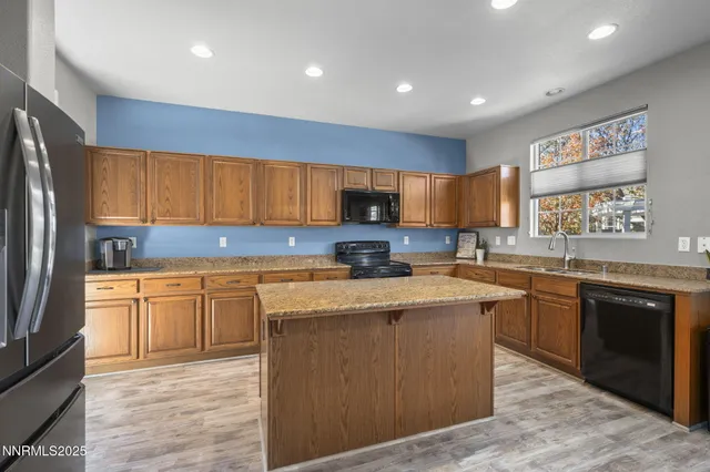 a kitchen with stainless steel appliances granite countertop a stove sink refrigerator and cabinets