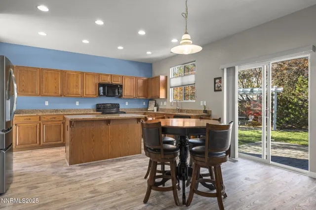 a kitchen with kitchen island granite countertop wooden floors and white cabinets
