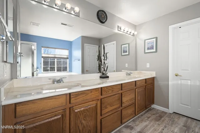 a bathroom with double vanity sinks a vanity a mirror and shower