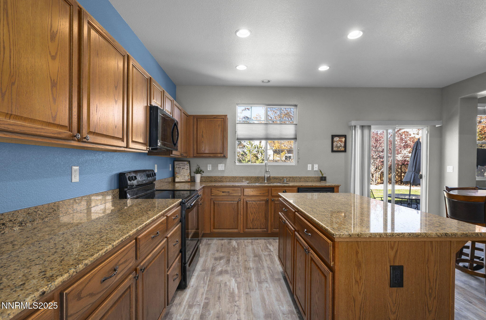 8963 Wynne Street Reno, NV 89506 - Photo 9 of 32 a kitchen with stainless steel appliances granite countertop sink stove microwave and cabinets
