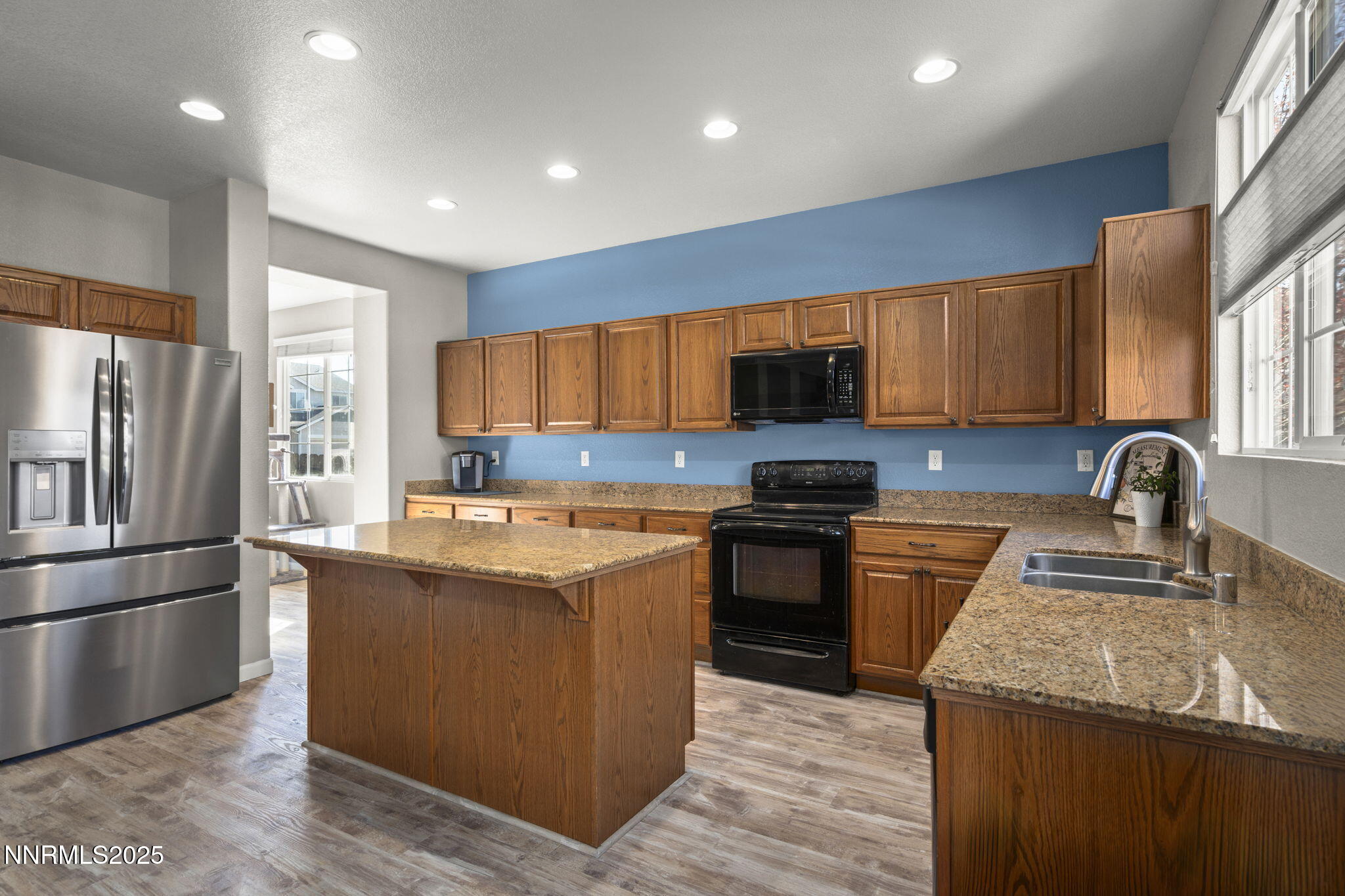8963 Wynne Street Reno, NV 89506 - Photo 10 of 32 a kitchen with stainless steel appliances granite countertop a stove top oven a sink and a refrigerator