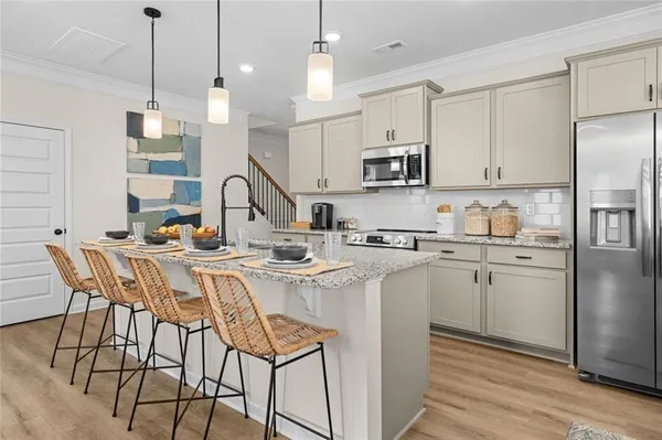 a open kitchen with stainless steel appliances granite countertop a sink a stove a refrigerator and island with wooden floor