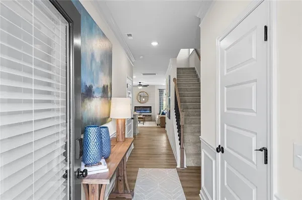 a view of a hallway with wooden floor and staircase