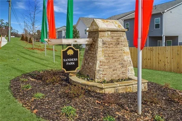 a sign board in front of a brick house