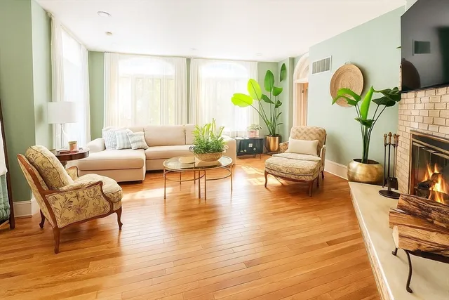 a living room with fireplace furniture and a wooden floor