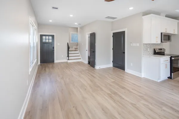 a view of a kitchen with wooden floor and windows