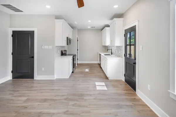 a view of a kitchen with refrigerator and wooden floor