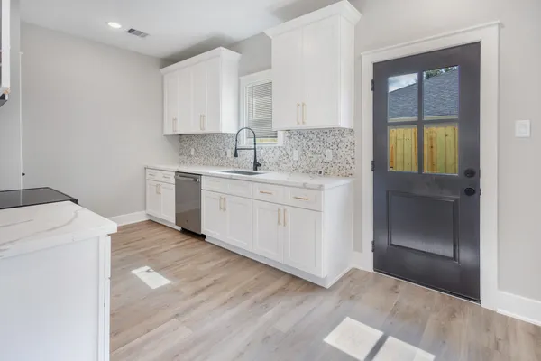 a kitchen with a sink cabinets and wooden floor