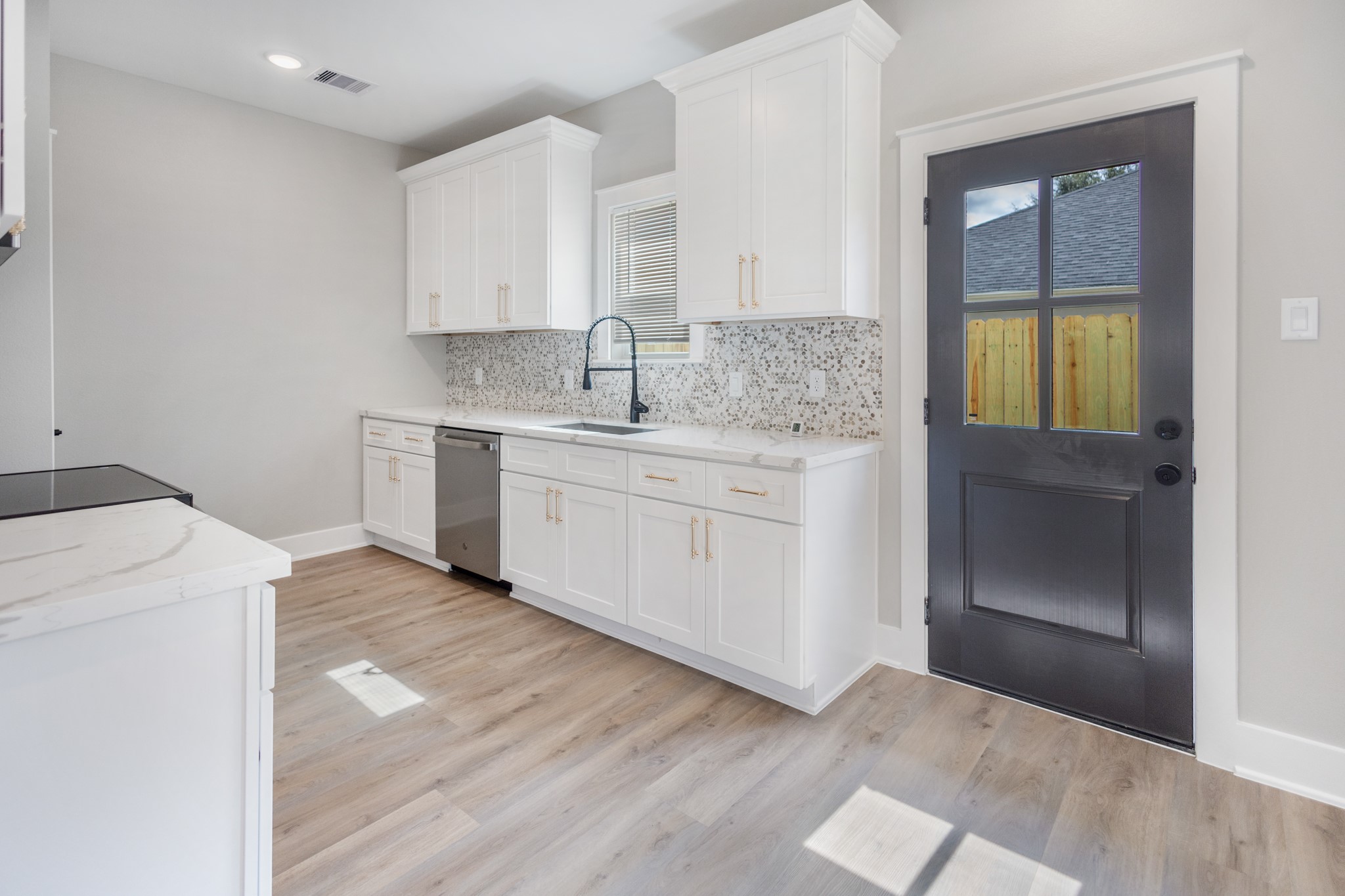 5036 Mallow Street, Unit A Houston, TX 77033 - Photo 15 of 36 a kitchen with a sink cabinets and wooden floor