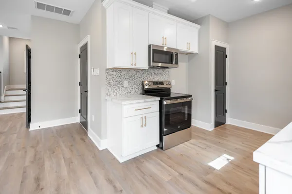 a kitchen with a sink a microwave and cabinets