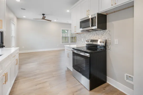 a kitchen with stainless steel appliances granite countertop a stove and a microwave