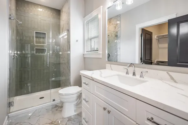 a bathroom with a sink a toilet and shower