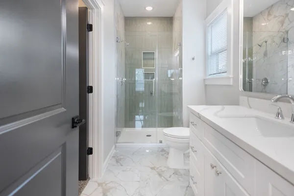 a bathroom with a sink a toilet and shower