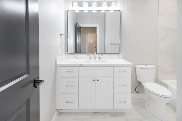 a bathroom with a toilet sink and mirror