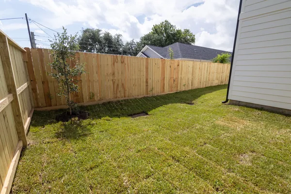 a view of a backyard with wooden fence