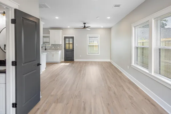 a open kitchen with white cabinets and wooden floor